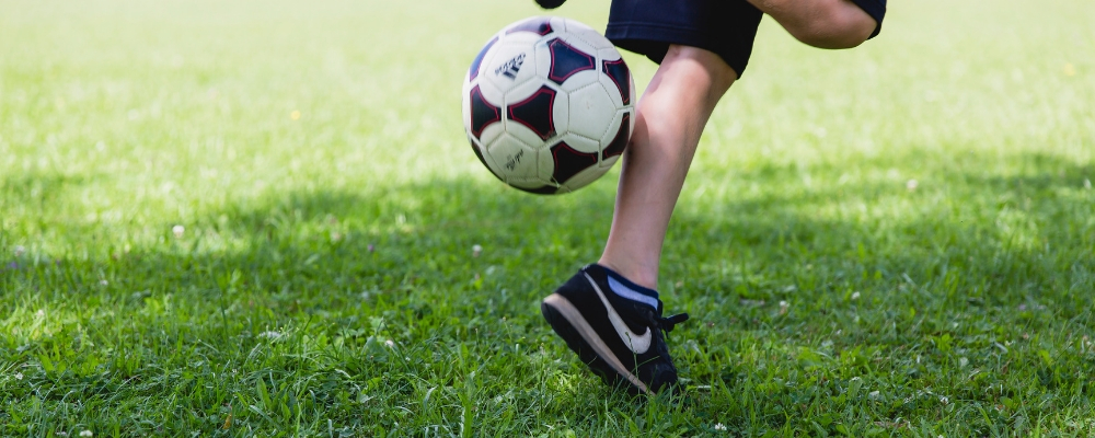 Boy kicking football in the open field