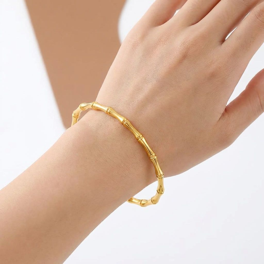 gemini-image-2_First_Photo_with_model_hand_Prompt_Close-up_shot_of_a_gold_bamboo_bracelet_worn_-0