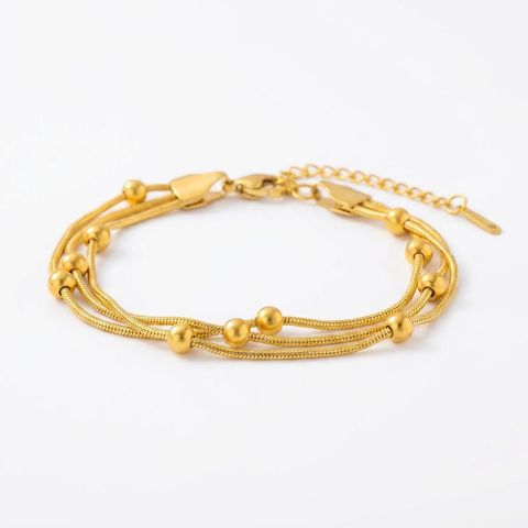 gemini-image-2_Prompt_A_side_angle_shot_of_the_gold_multi-strand_bracelet_placed_on_a_pure_whit-0