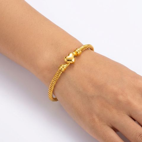 gemini-image-2_First_Photo_worn_on_model_s_hand_one_wrist_Prompt_Close-up_shot_of_a_gold_twiste-0