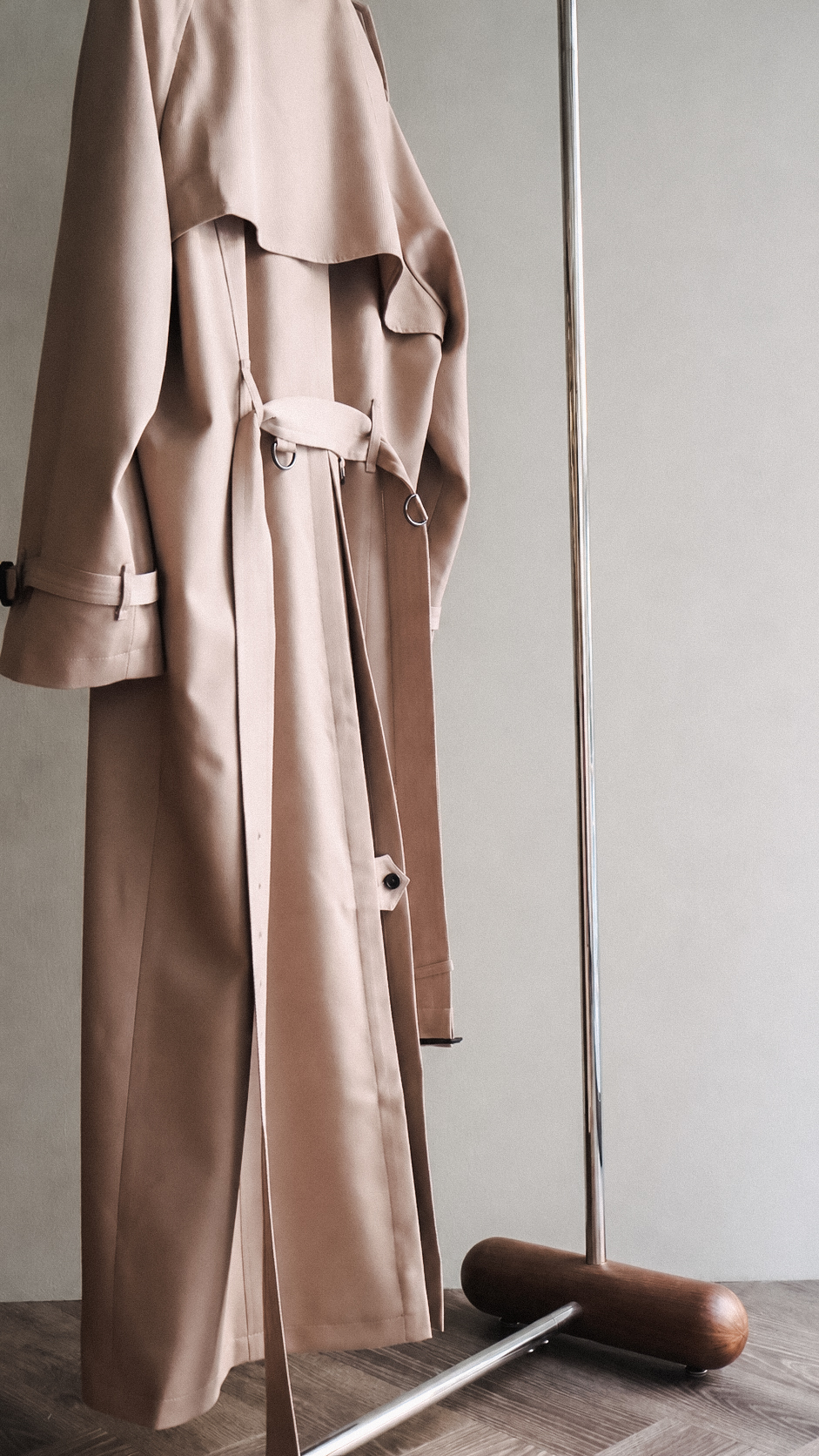 Beige trench coat on a freestanding rack