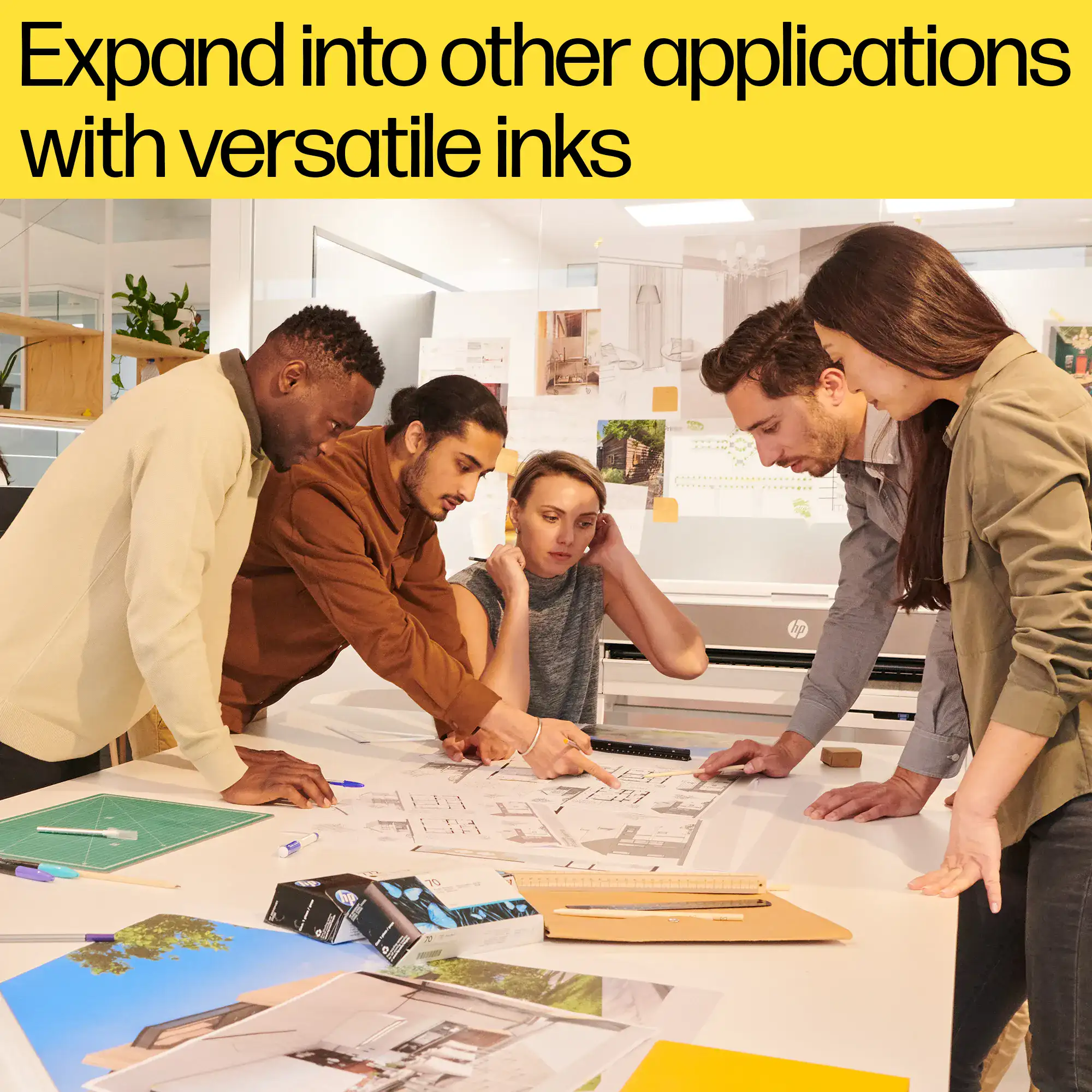 Team collaborating on a large-format print, demonstrating the versatility of HP Flex Tech Inks for both technical drawings and posters.
