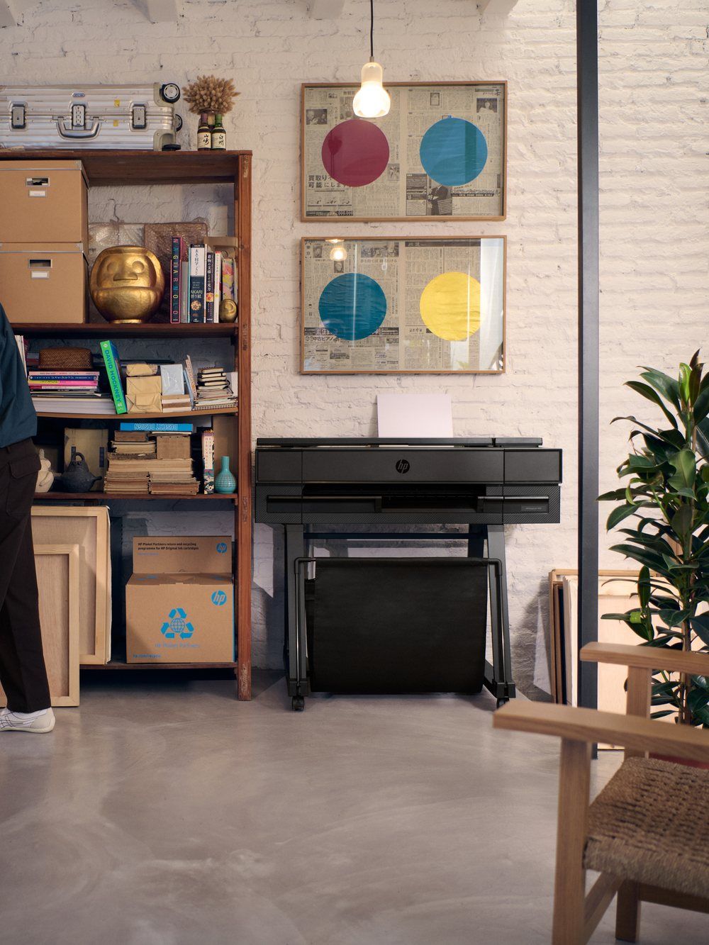 Architects reviewing drawings beside an HP DesignJet T870 plotter in a bright studio