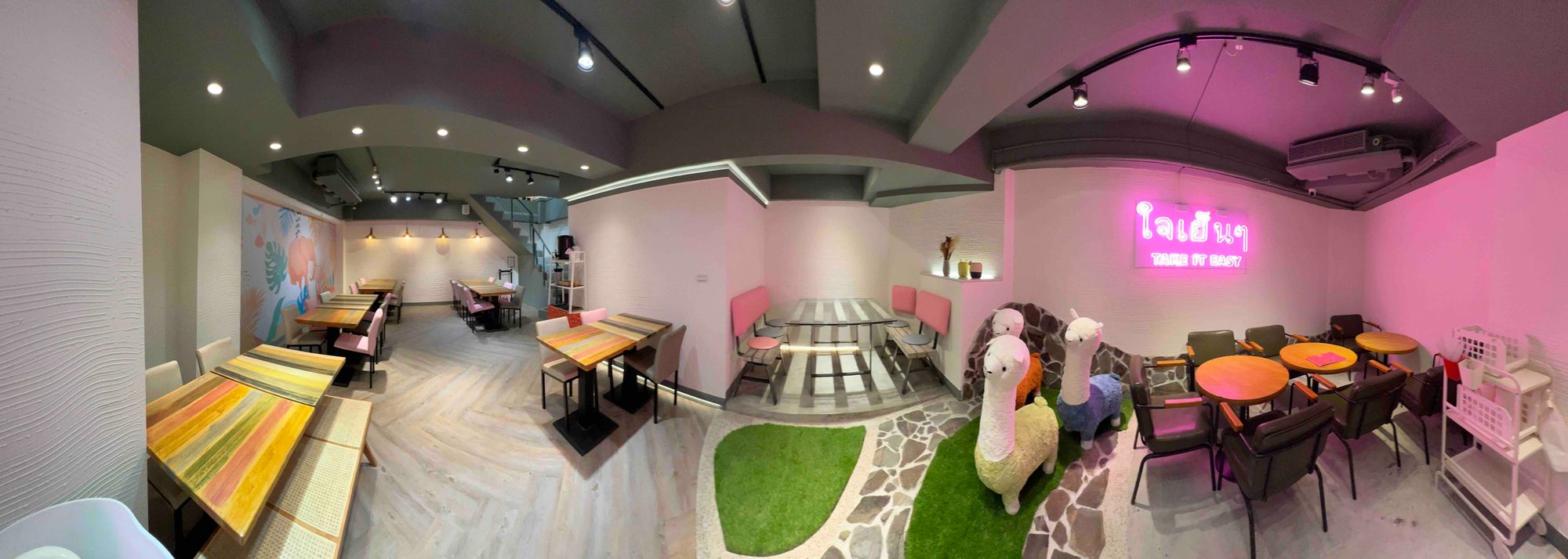小食泰店內木色餐桌、彩色座椅與霓虹招牌的全景