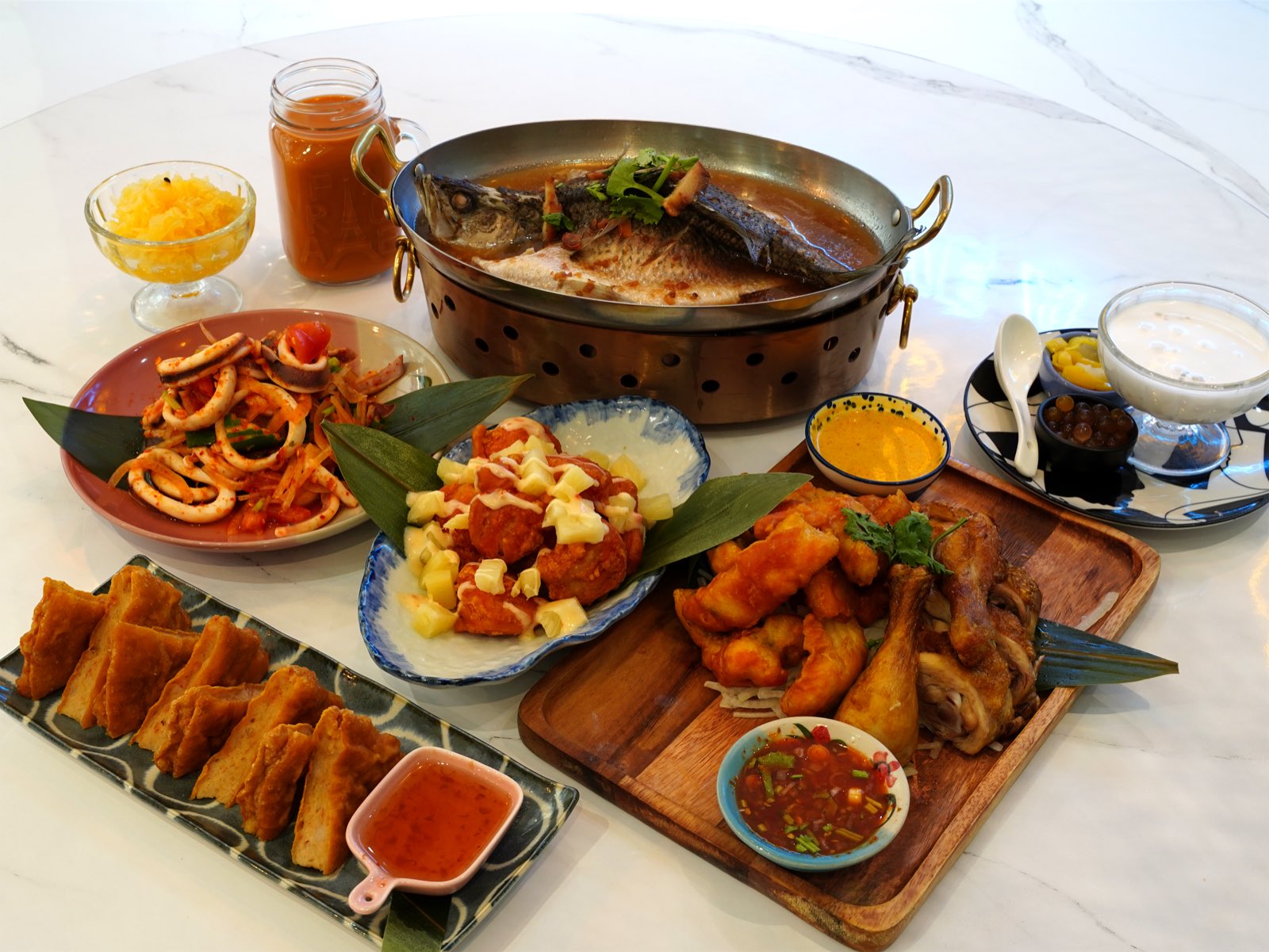 小食泰泰式共享餐桌，魚料理、蝦餅與多道合菜的搭配情境