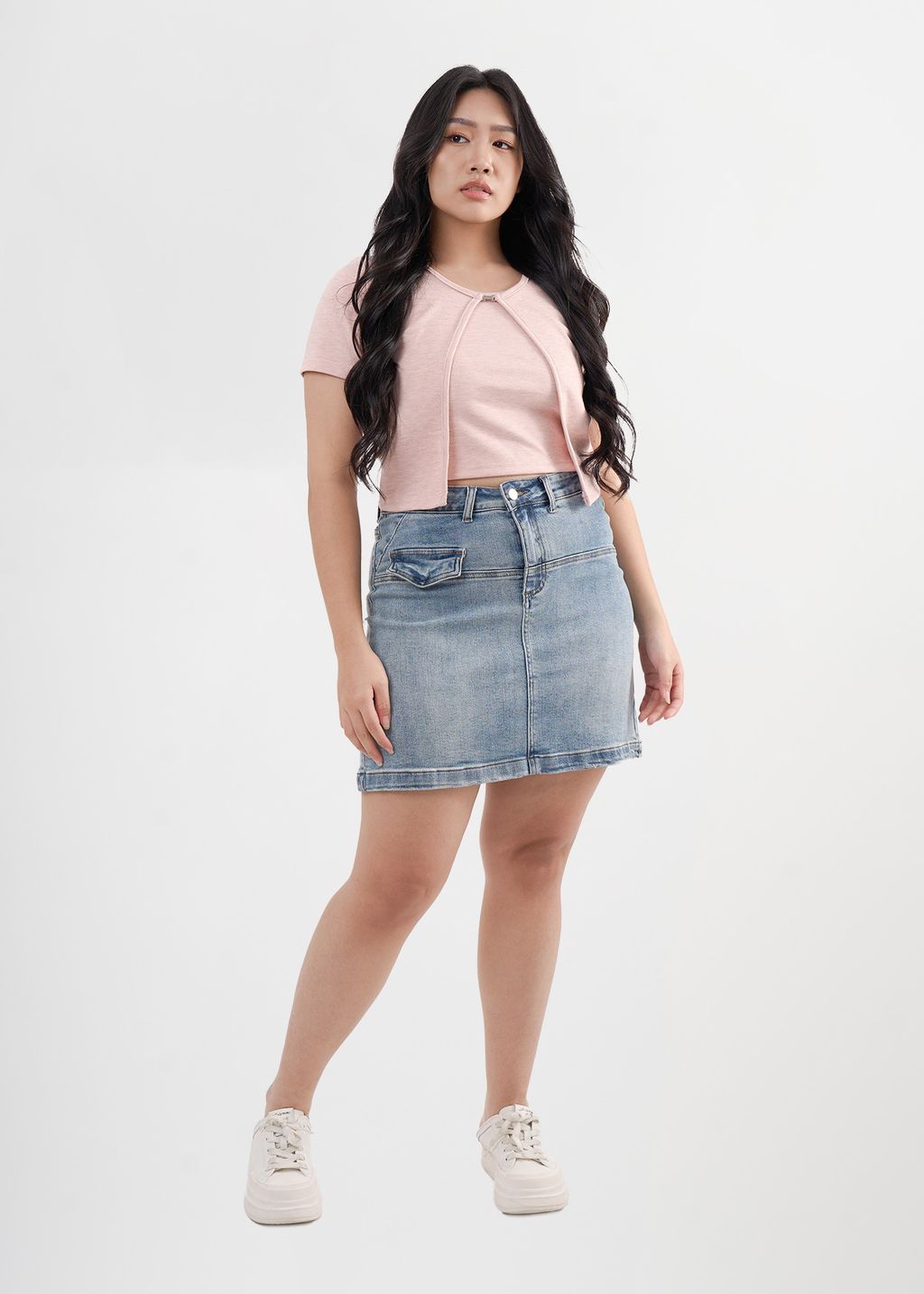 Pink cropped cardigan with short sleeves and front clasp, styled for curvy figures.