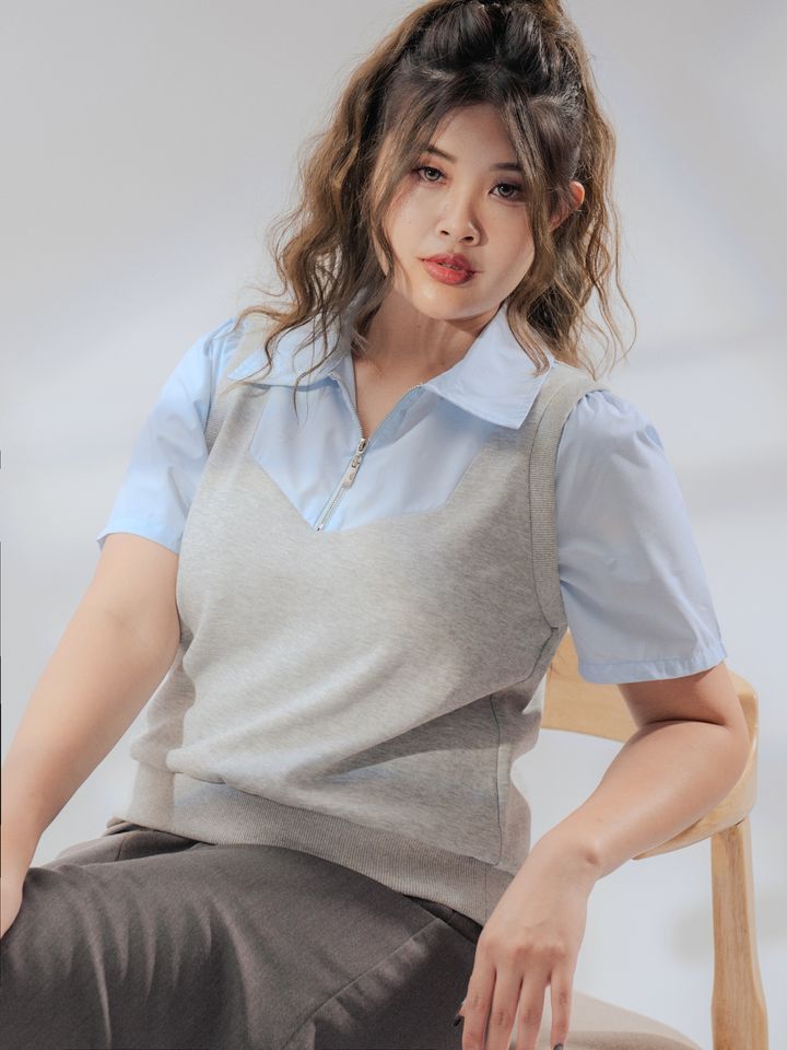 Stylish sleeveless knit top designed to flatter curves with a modern layered hem.
