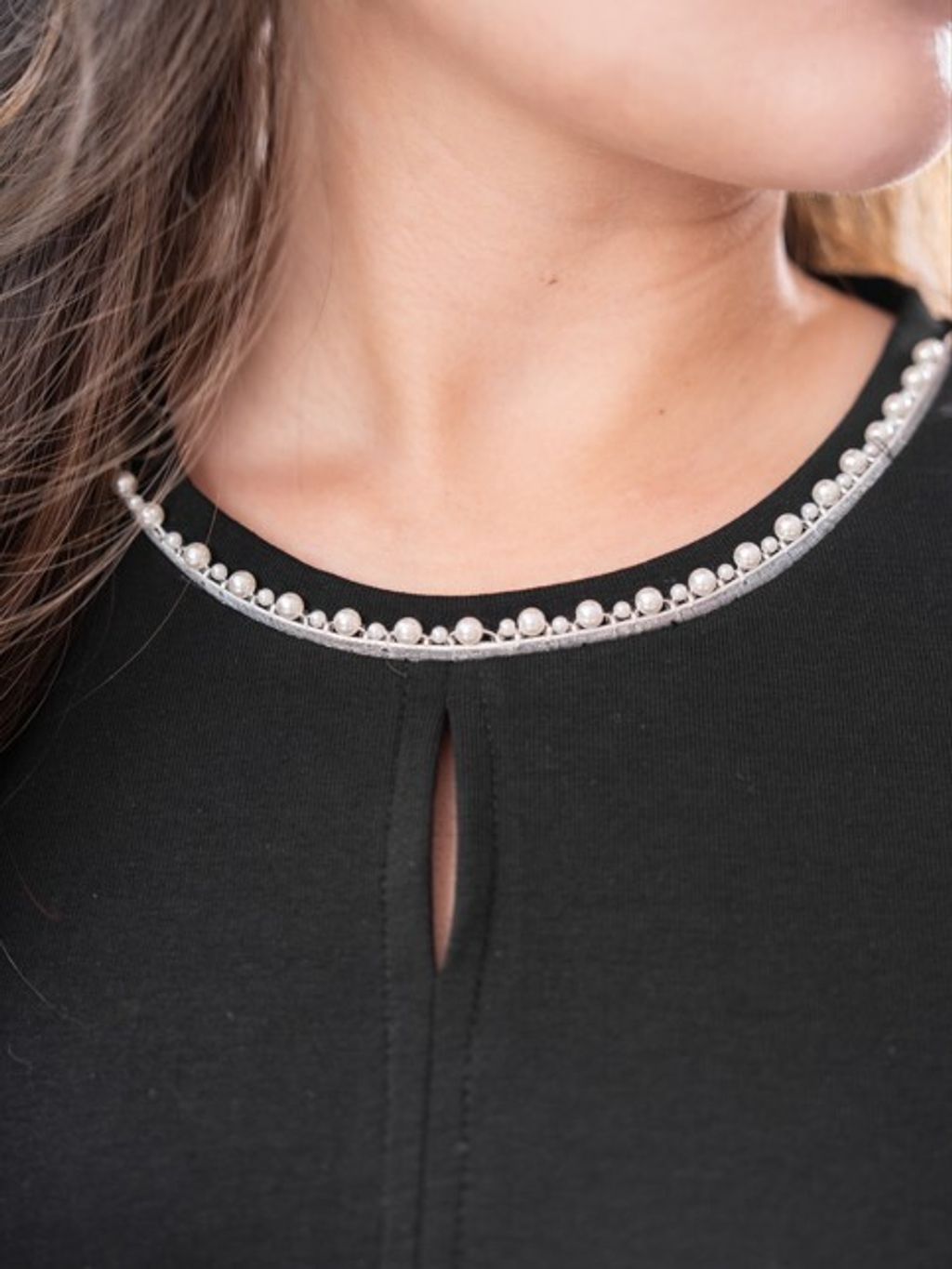 Plus size blouse with shimmering pearl details, blending sophistication and comfort.