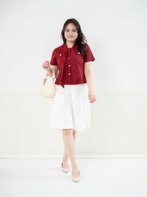 Plus size woman wearing dark red short-sleeve blouse with bow tie detail