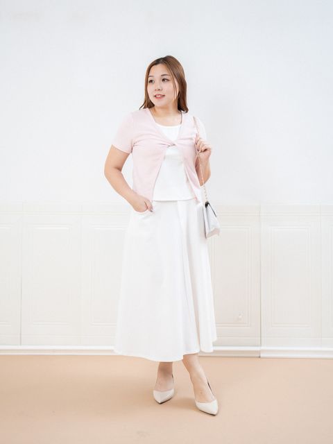 Plus size model wearing Soft Twist Cover Knit in light pink, front twist design.