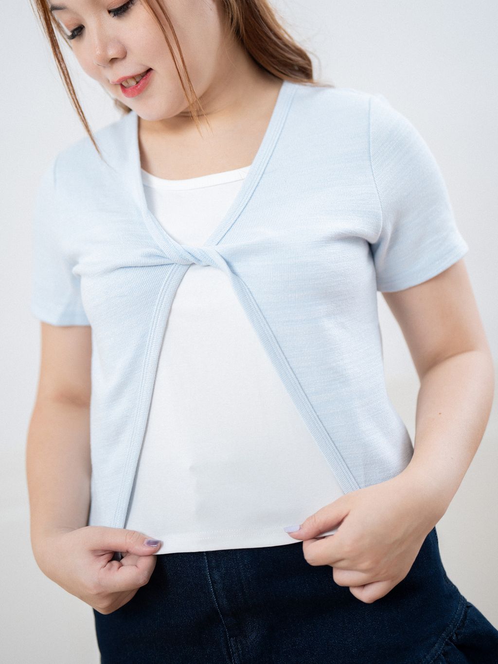 Close-up of front twist design on breathable plus size knit cardigan.