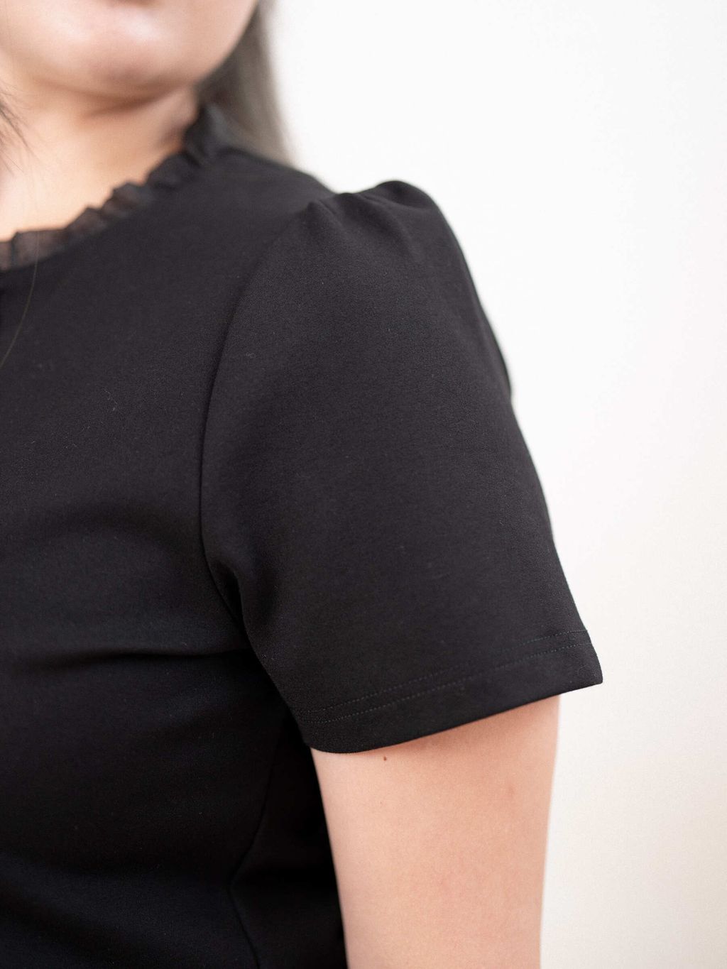 Soft structured sleeve on plus size top designed for arm coverage and comfort.