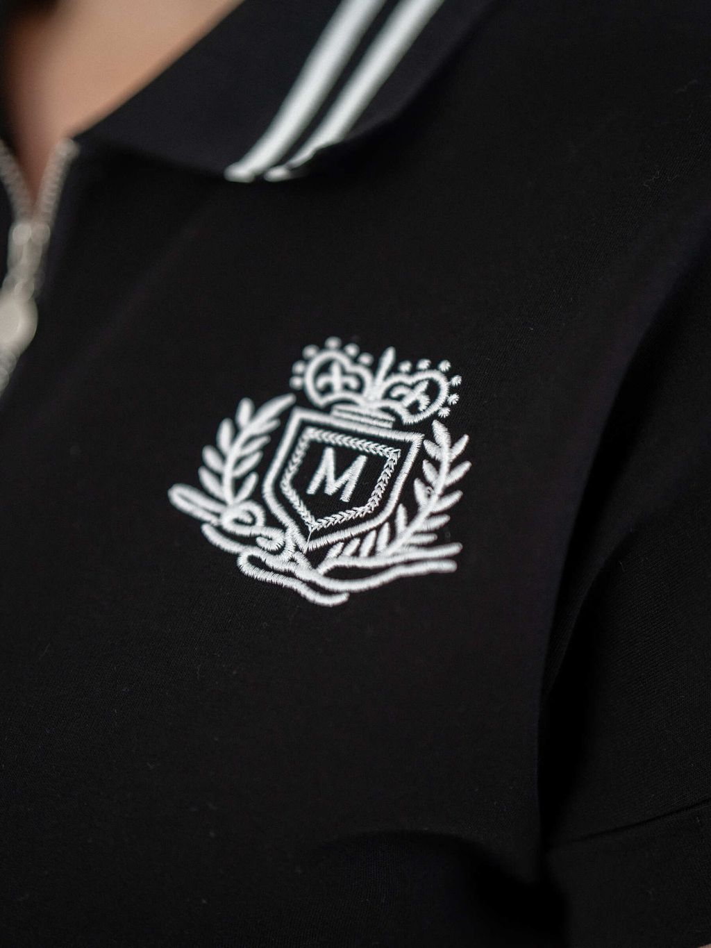 Front view of Varsity Charm Polo showing embroidered crest and sporty neckline