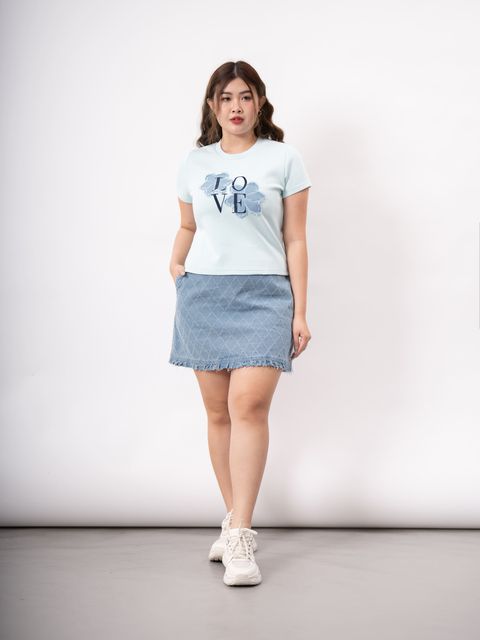 Plus-size model wearing white tee with denim flower and LOVE text