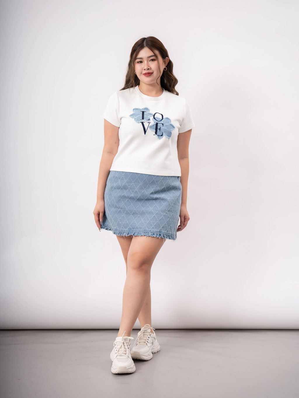 Front pose of model in white tee with denim floral embroidery