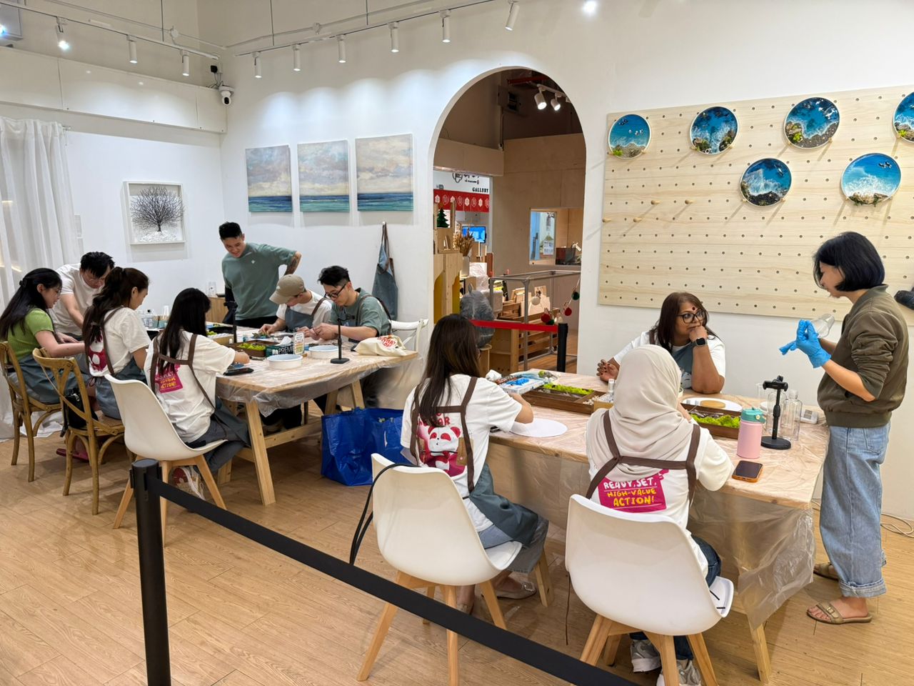 a group of people sitting together to craft their resin ocean artwork