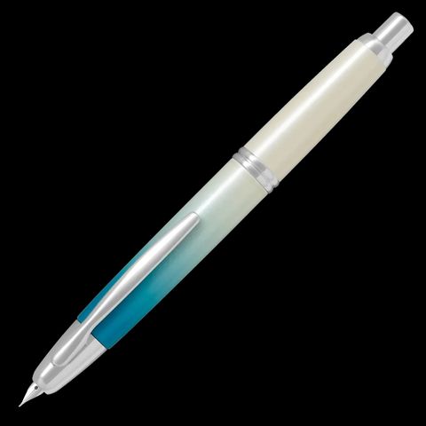 A PILOT Capless retractable fountain pen, featuring a limited edition barrel design called Seashore, that transitions from deep sea turquoise to a shimmering white, evoking pure sand on a coastline.