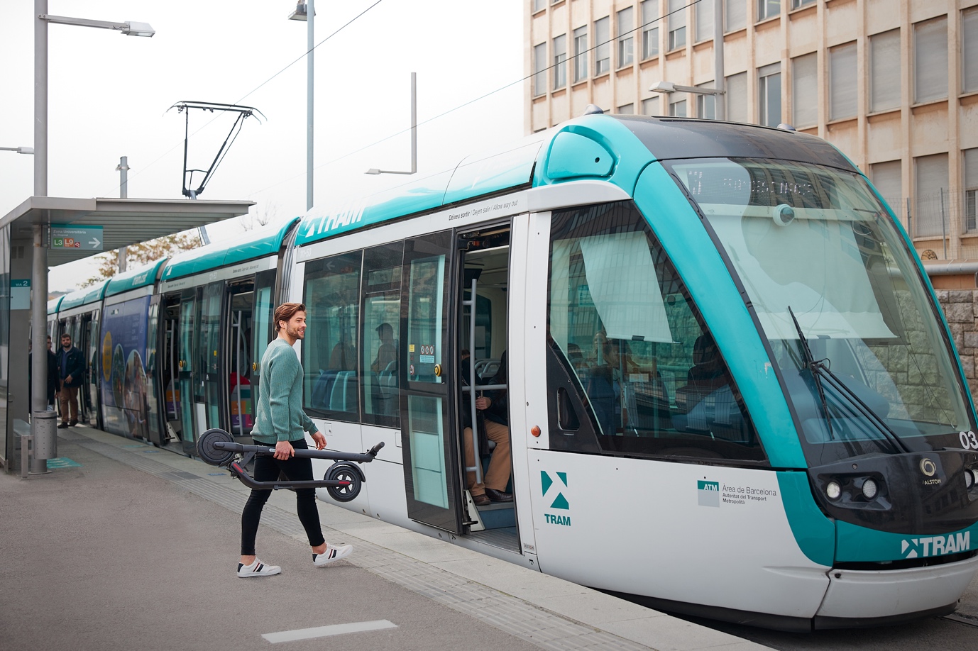 A group of people walking down a street next to a train

Description automatically generated