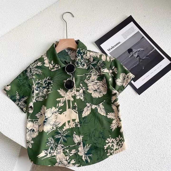 綠底米色花紋短袖襯衫，衣架吊掛展示