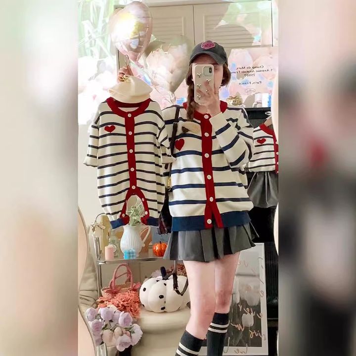 米白底深藍條紋愛心開襟毛衣，手持同款童裝的鏡前穿搭