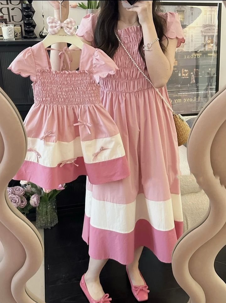 粉色胸前皺褶泡泡袖母女洋裝近照，展示白色拼接裙襬