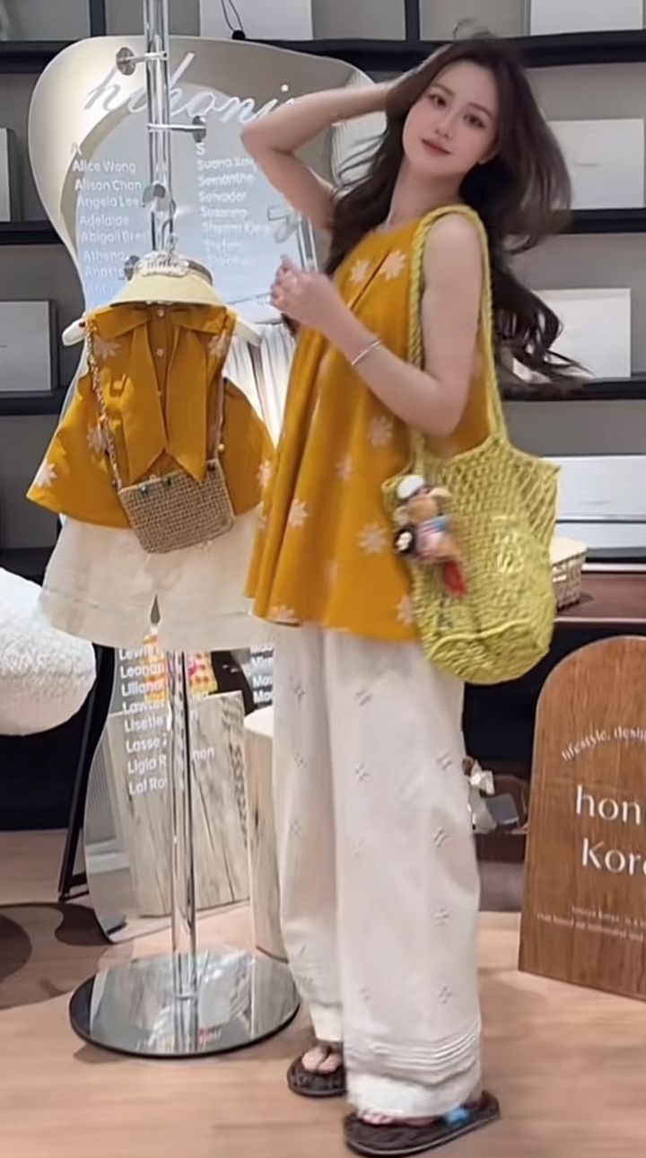 芥黃色白花無袖上衣與白色裙褲母女裝側身展示