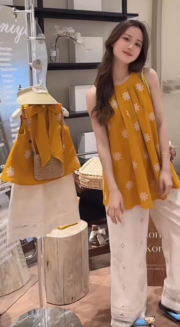 媽媽穿芥黃色白花無袖上衣與白色鏤空長褲，旁邊展示女童套裝