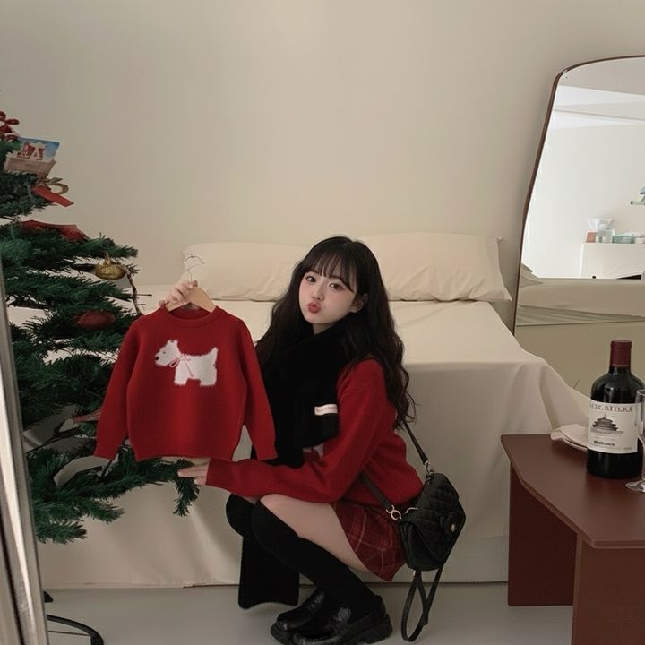 紅色白狗圖案毛衣，成人手持同款童裝的室內蹲姿