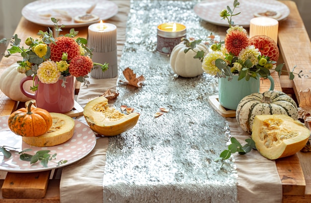close-up-cozy-decor-details-festive-autumn-dining-table-with-pumpkins-flowers-candles_169016-15511