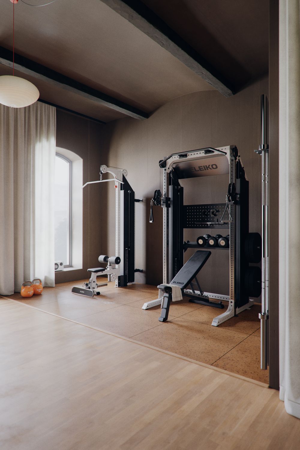 A home gym with an Eleiko rack, bench and lat pulldown by an arched window