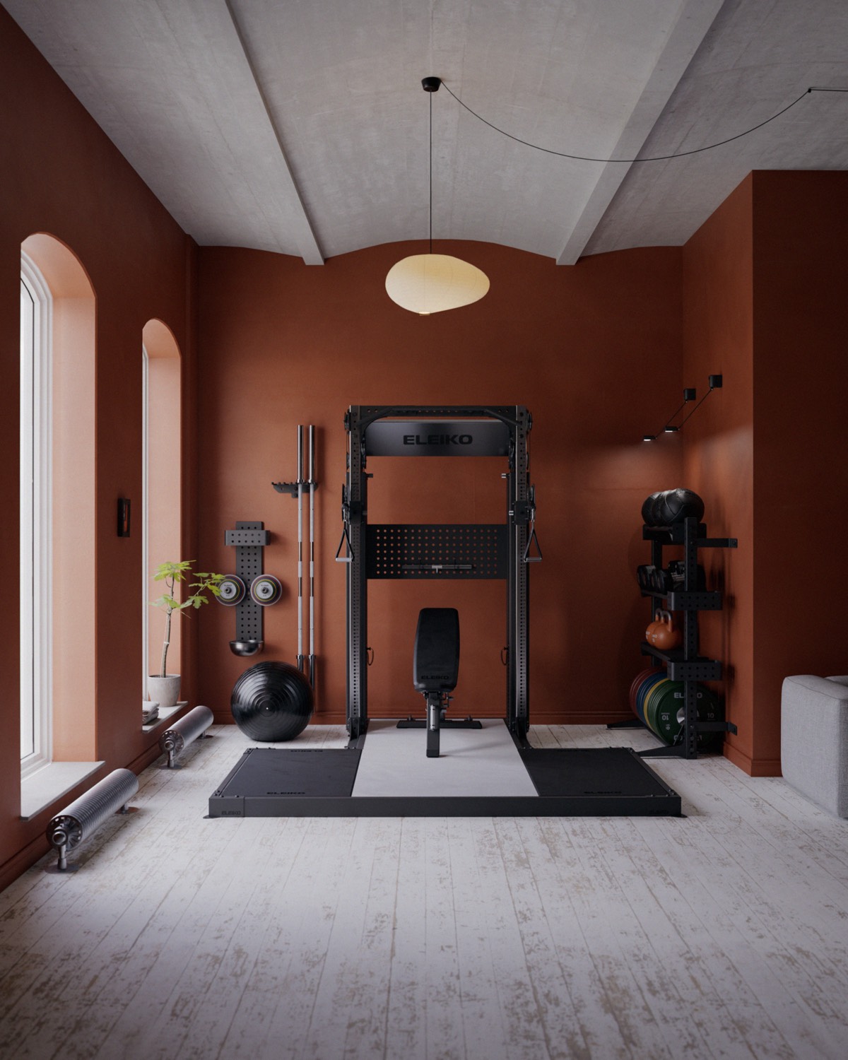 A home gym with an Eleiko rack and bench in a terracotta room with arched windows