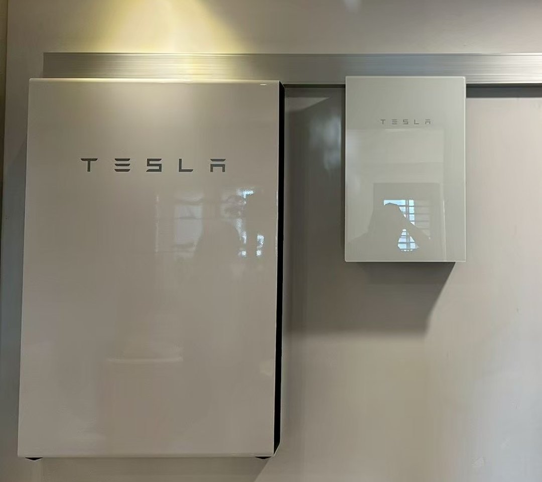 崧象智能安裝實績：室內牆面並排壁掛的 Tesla Powerwall 與 Backup Gateway，上方是鋁製線槽