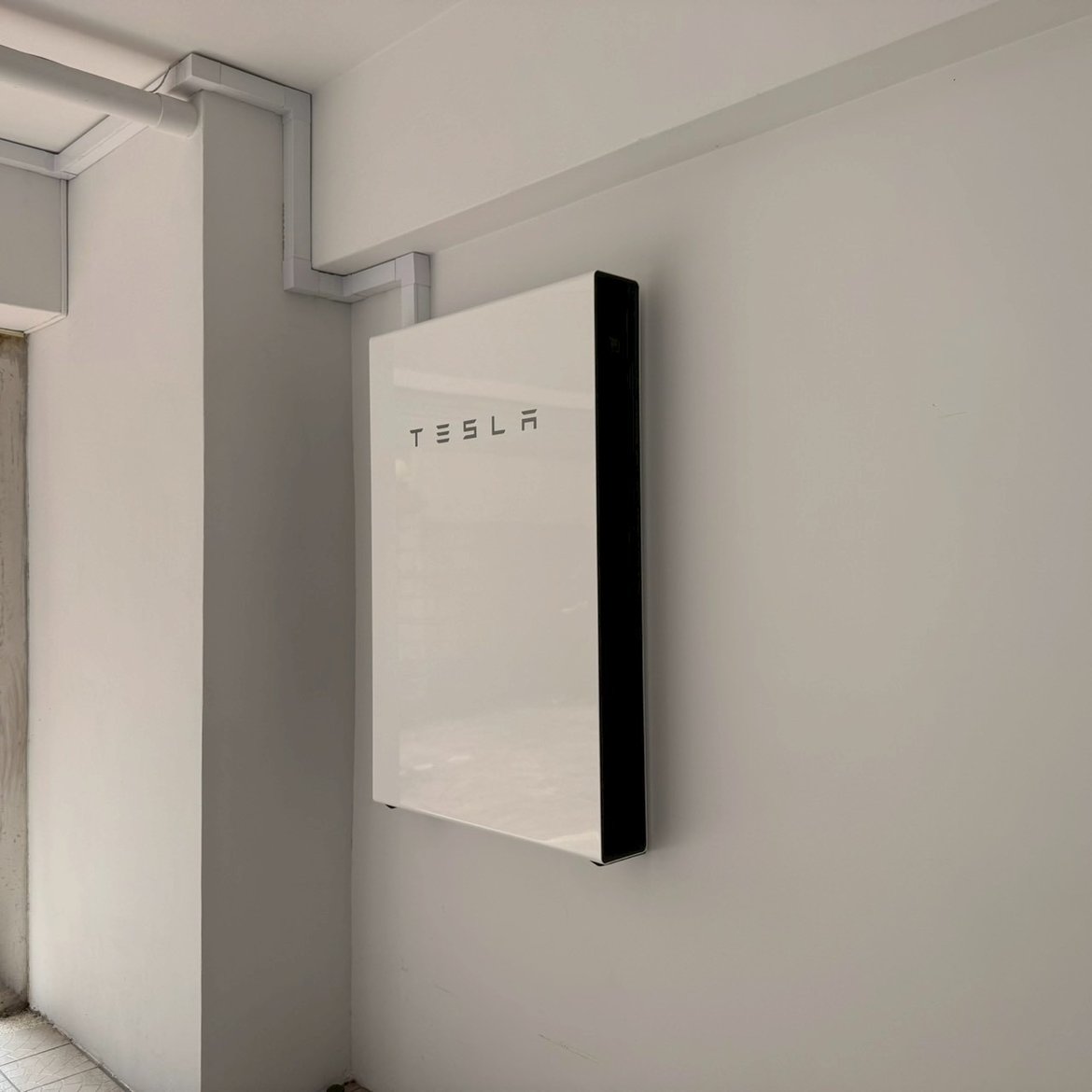 崧象智能安裝實績：室內牆面壁掛的一套 Tesla Powerwall，線槽從天花板接入