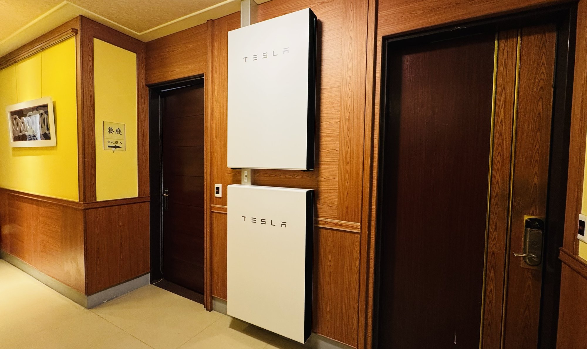 崧象智能在商業空間安裝的 Tesla Powerwall,Powerwall×2 上下壁掛在走廊的木紋牆面