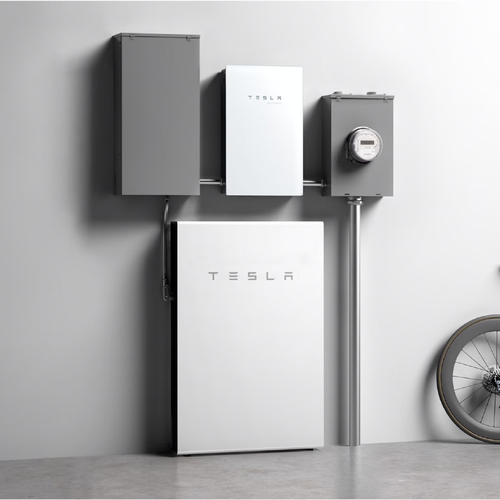 Tesla 官方示意圖：牆上由左到右是住家配電箱、Backup Gateway、台電電表箱，下方是 Powerwall；Gateway 接在電表與配電箱之間