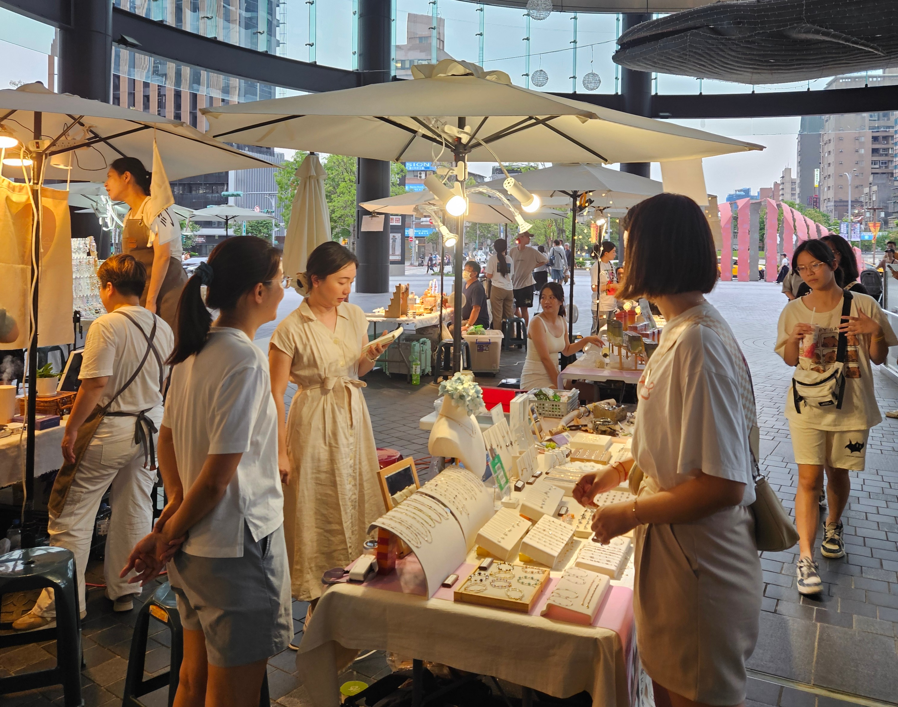 顧客正在市集攤位挑選銀飾，現場氣氛溫馨，設計師親自介紹商品nt