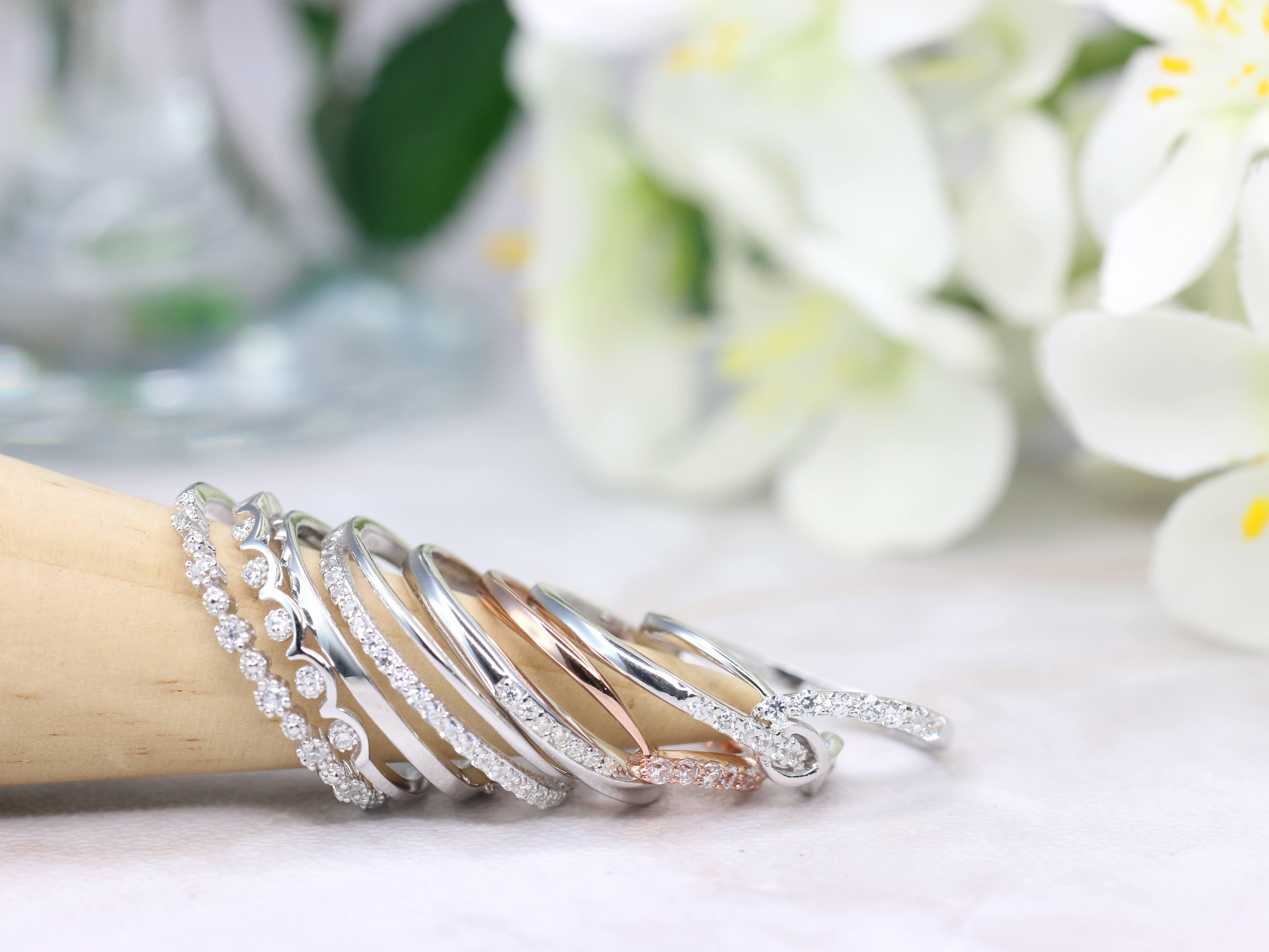 多款925銀戒指展示,其中包含鍍銠與鍍K金設計,呈現亮白與玫瑰金色澤