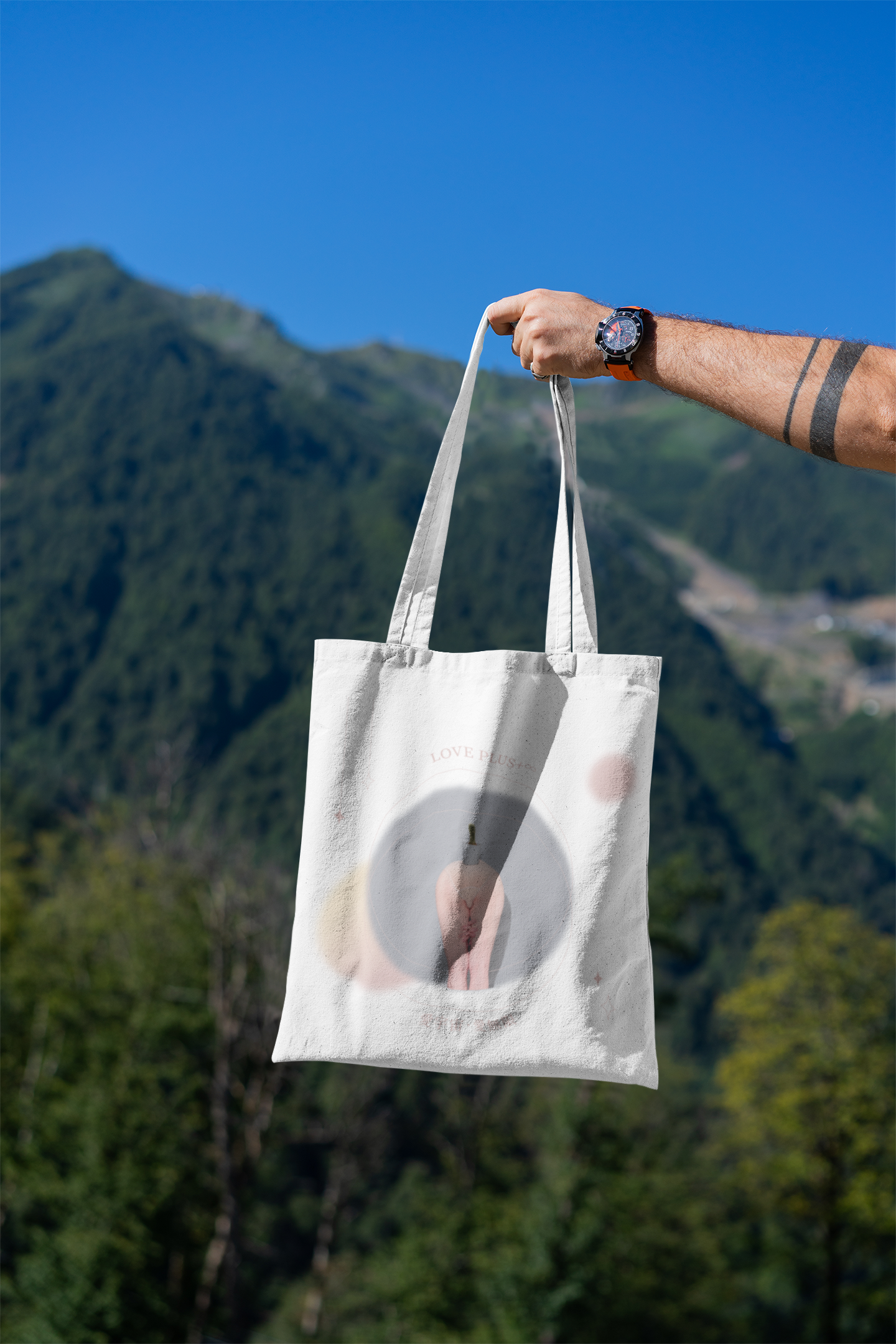 mockup-featuring-a-man-s-hand-holding-a-tote-bag-against-a-natural-scenery-3131-el1