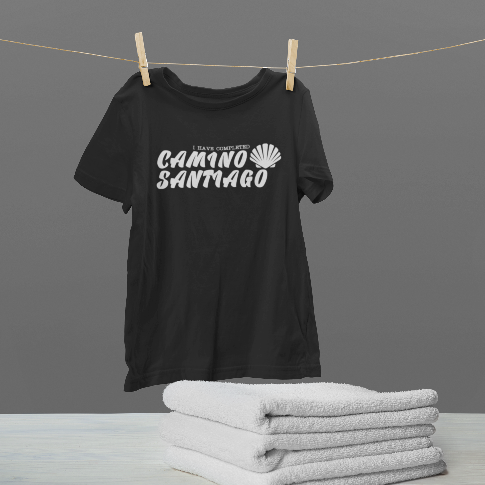 mockup-of-a-hanging-t-shirt-by-some-folded-towels-46150-r-el2