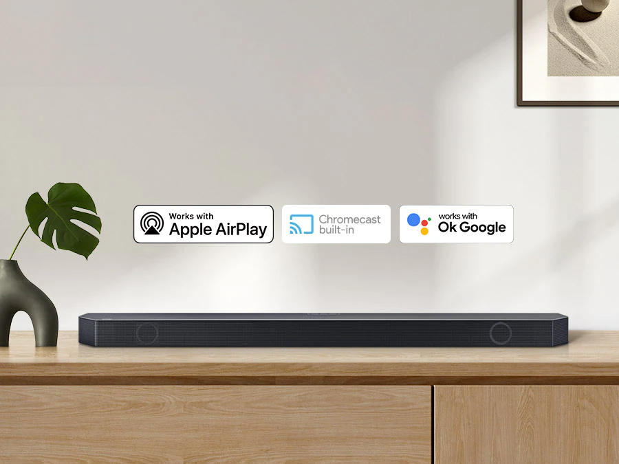 Description: Chromecast built-in logo and Works with OK Google and Apple AirPlay logos with a Samsung Q series Soundbar.