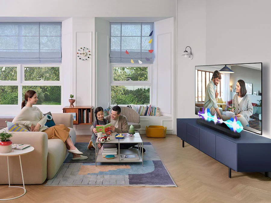 Description: A woman watches TV while her husband and child play. Simulated sound waves show Active Voice Amplifier technology optimizing the onscreen dialogue, so it can be heard more clearly in noisy environments.