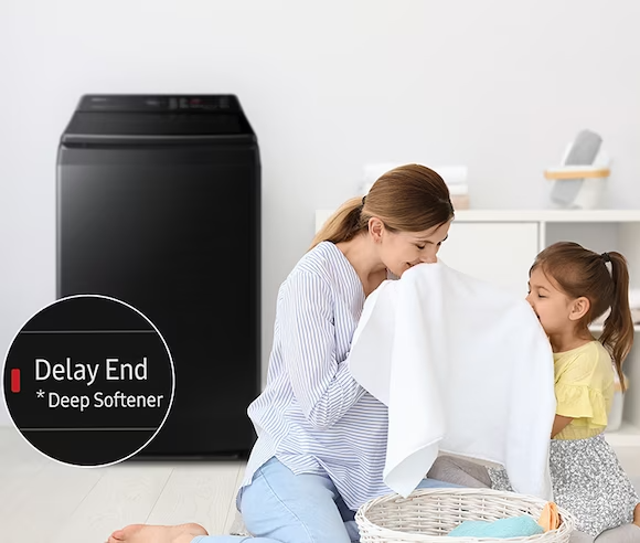 Description: Side of the washing machine, a woman is smelling a towel with her daughter. The towel was washed using the Deep Softenter of the Delay End course.
