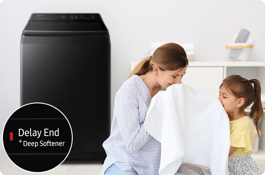 Description: Side of the washing machine, a woman is smelling a towel with her daughter. The towel was washed using the Deep Softener of the Delay End course.