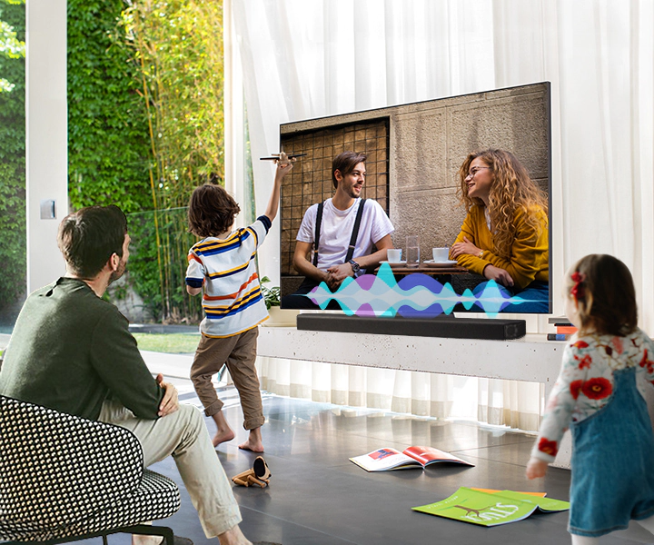A man watches TV while his children play. Simulated sound wave graphics show Active Voice Amplifier technology optimizing dialogue so it can be heard more clearly in noisy environments.