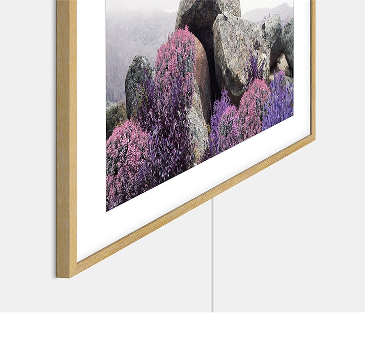 The Frame which is hung on the wall with Slim-fit Wall Mount shows barely visible gap between TV and wall, as well as transparent One Invisible Connection wire.