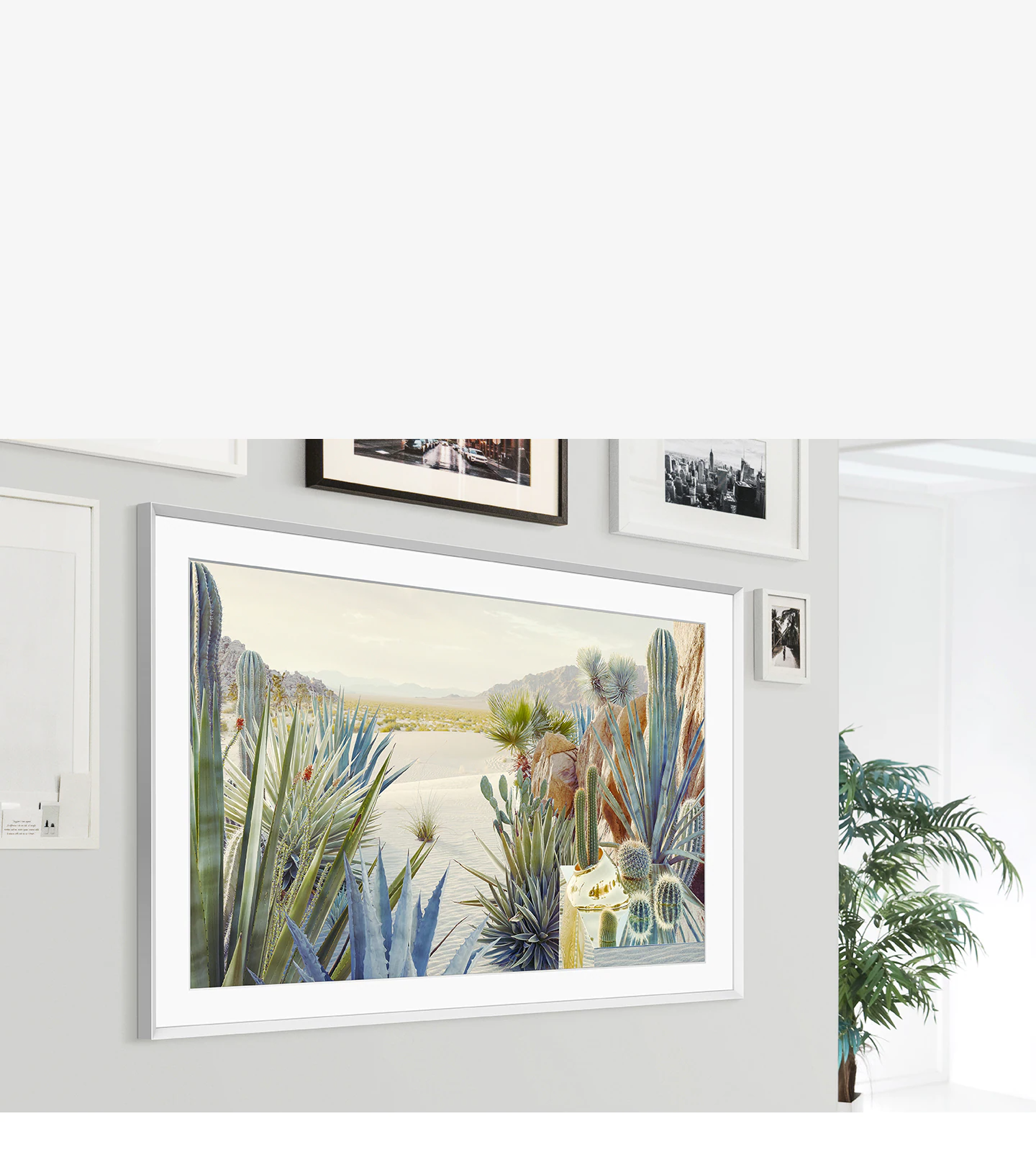 The Frame is mounted on the wall of a home interior and its modern frame design blends with the other picture frames on the wall.