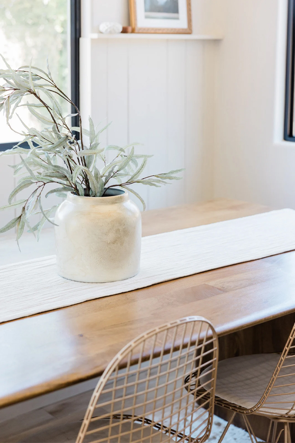 Minimalist concrete vase on white tablecloth dining table