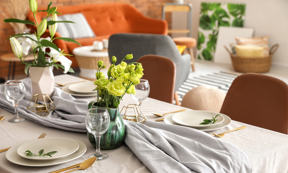 Green flowers and layers of plate on dining table