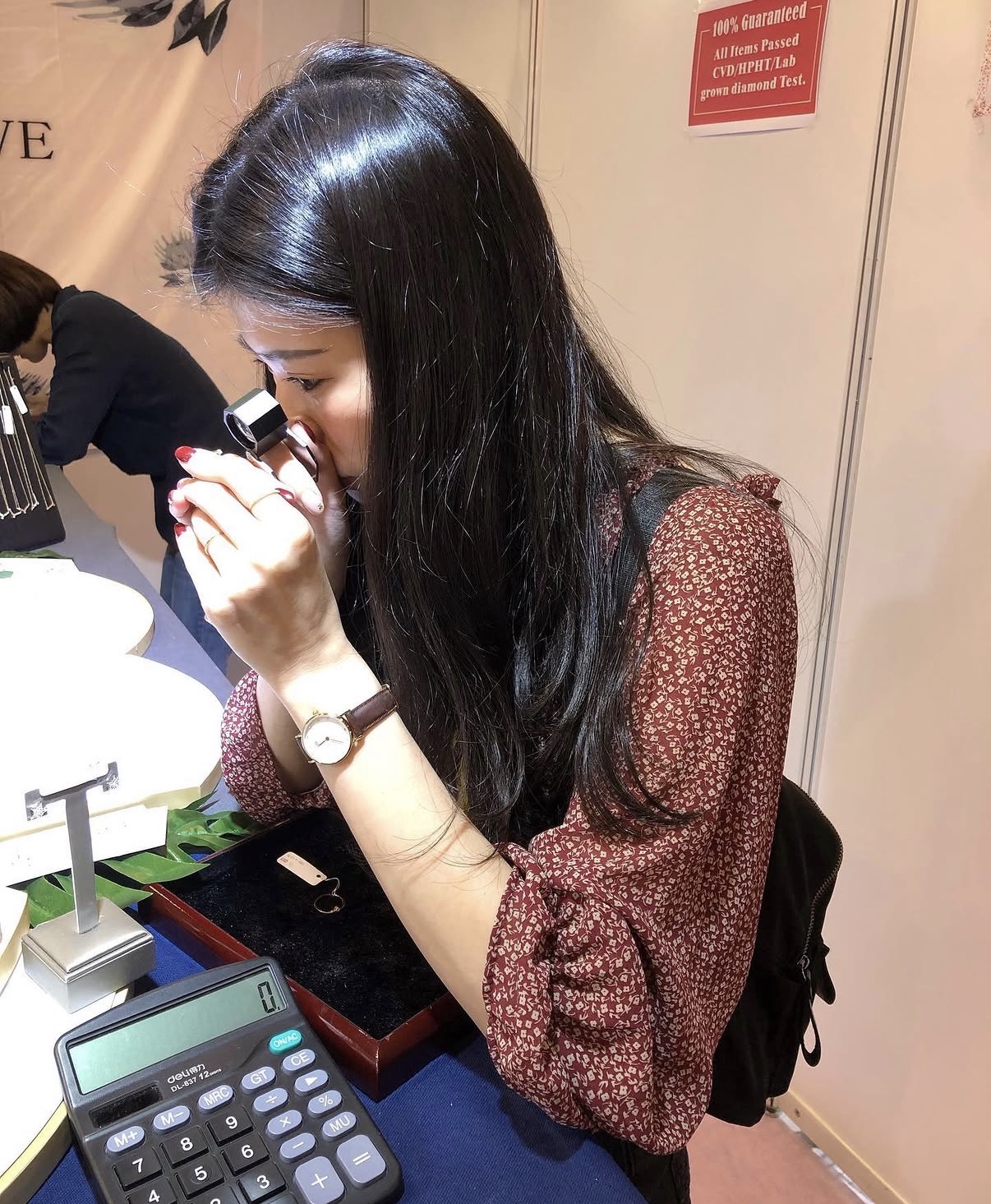幸李輕珠寶創辦人於香港珠寶展現場以放大鏡檢視鑽石品質