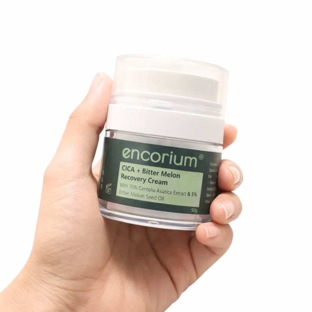 Hand holding a 50g jar of Encorium CICA + Bitter Melon Recovery Cream